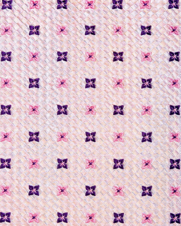 Närbild av lila blommor över en rutig rosa botten på AURORA, bred slips i rosa och lila