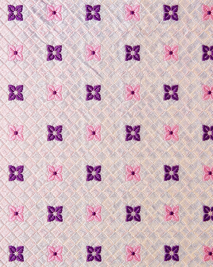 Närbild av rosa och lila blommor över en rutig struktur på Aurora smal, smal slips i rosa och lila