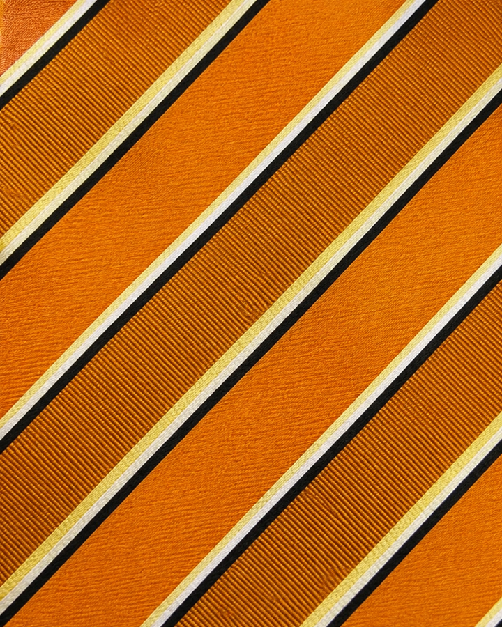 Närbild av randigt mönster på CHRISTOFFER, bred slips i svart, vitt, gult och orange