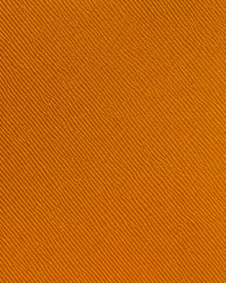 Närbild av enfärgad design utan synliga ränder på CUPRUM SMAL, smal slips i kopparorange