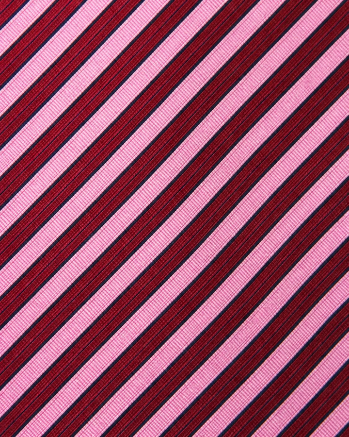 Närbild av växelvisa rosa och mörkt vinrödsvarta ränder på DIANA SMAL, smal slips i rosa och mörkt vinrödsvart