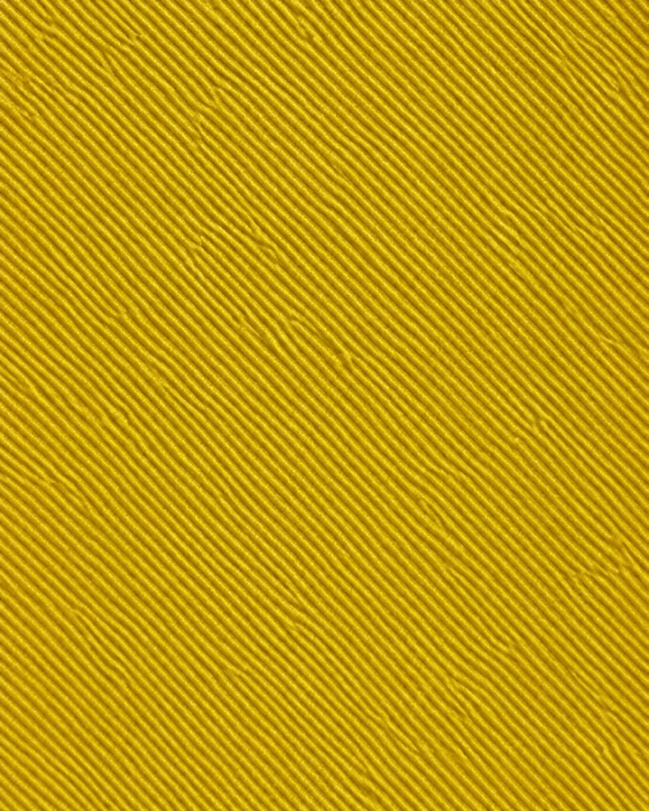 Närbild av en enfärgad design med vävd diagonal struktur på DOTT, bred slips i guldgult