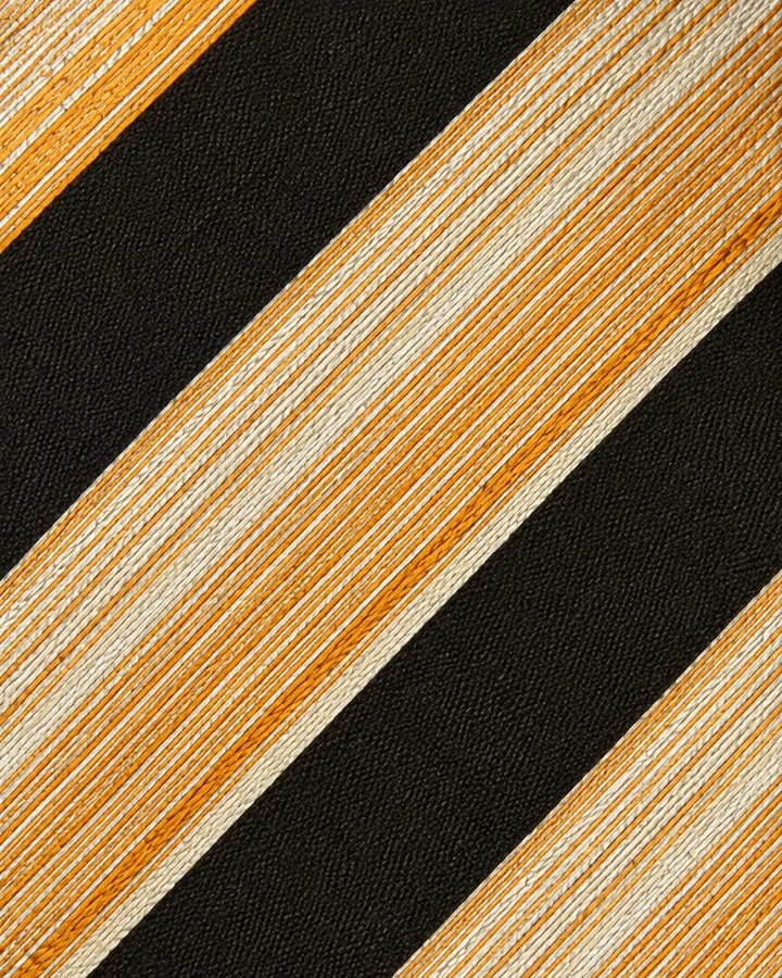 Närbild av randigt mönster på ELIS SMAL, smal slips i svart, gult, guld och orange
