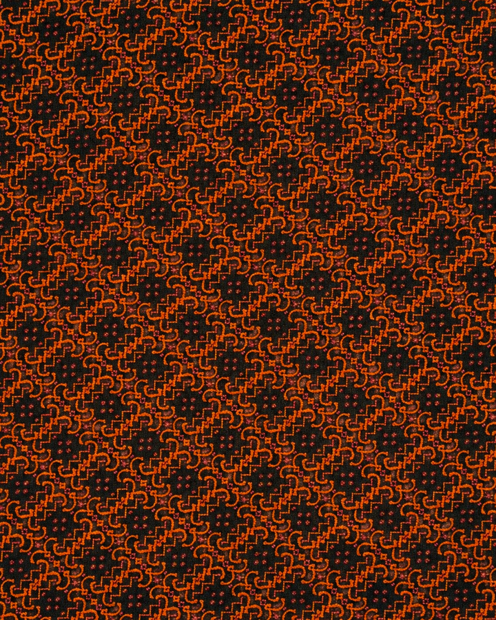 Närbild av ett tätt sammanlänkat orange geometriskt motiv på svart botten på FURINA, bröstnäsduk i svart och orange