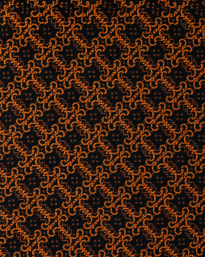 Närbild av ett tätt sammanlänkat orange geometriskt motiv på svart botten på FURINA SMAL, smal slips i svart och orange