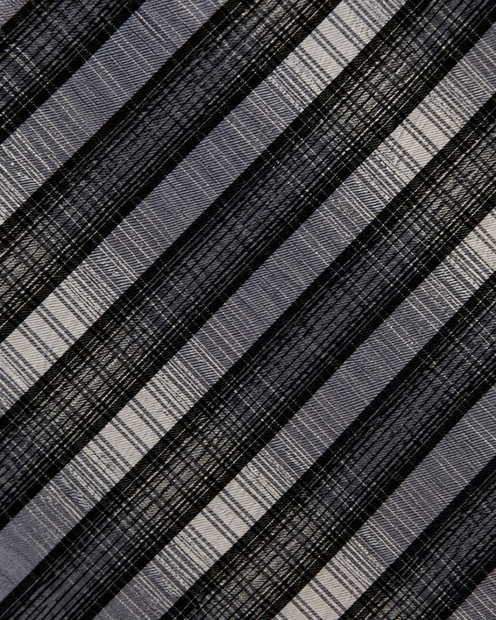 Närbild av randigt mönster på HUGO, bred slips i svart och silver