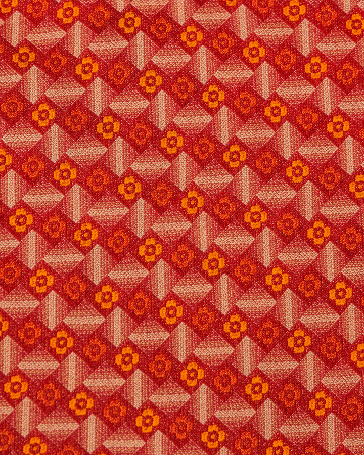 Närbild av blommigt motiv på JUSTITIA, bröstnäsduk i orange