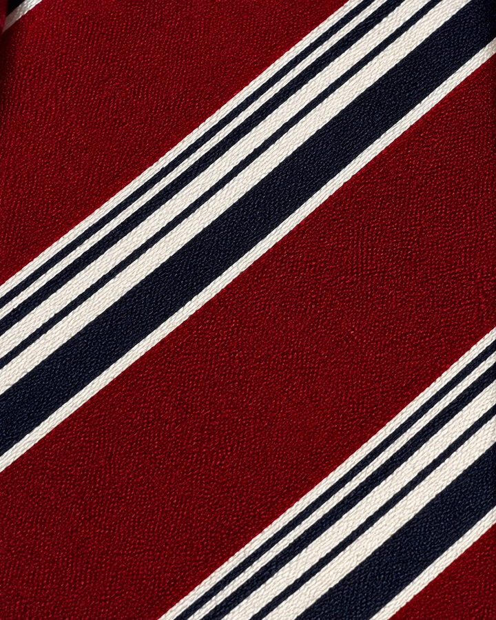 Närbild av randigt mönster på LEON SMAL, smal slips i svart, vitt, rött och blått
