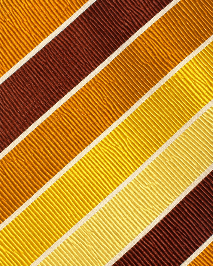 Närbild av randigt mönster på LOVE, bred slips i vitt, gult, brunt och orange