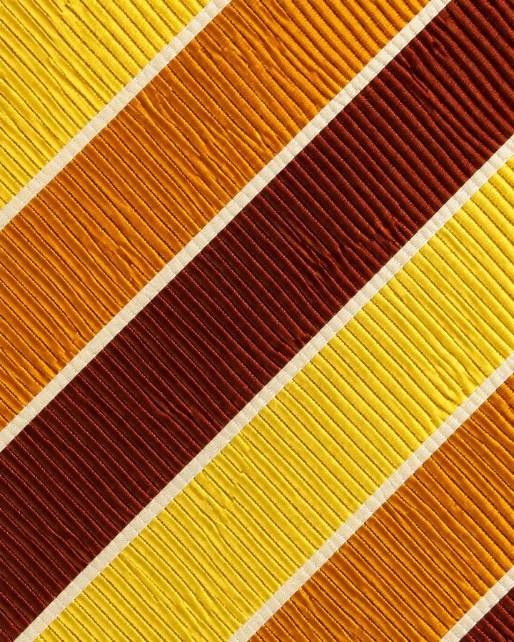 Närbild av breda diagonala band med fin ribbad randstruktur på LOVE SMAL, slips i brunt, orange, gult och vitt