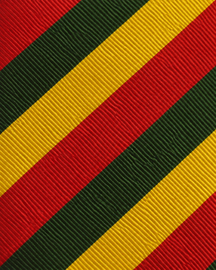 Närbild av randigt mönster på MARLEY, bred slips i rött, grönt och gult
