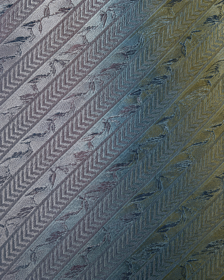 Närbild av upprepade bladmotiv ordnade i diagonala silverband på MEFITIS SMAL, smal slips i silver