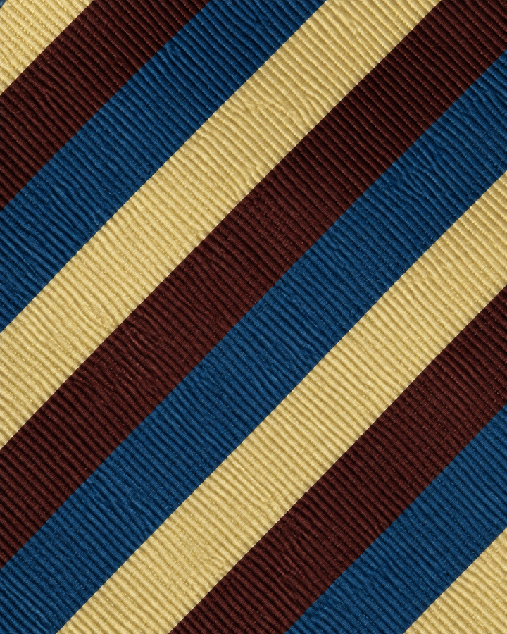 Närbild av randigt mönster på MUTED, bred slips i rött, blått och gult