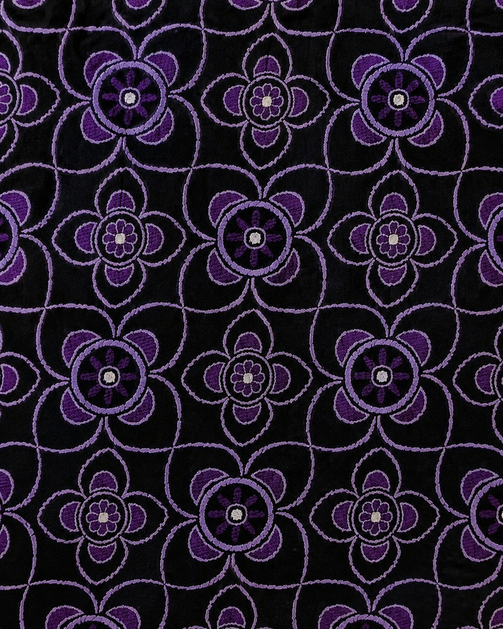 Närbild av blommigt motiv på OMIKRON, bröstnäsduk i lila och svart