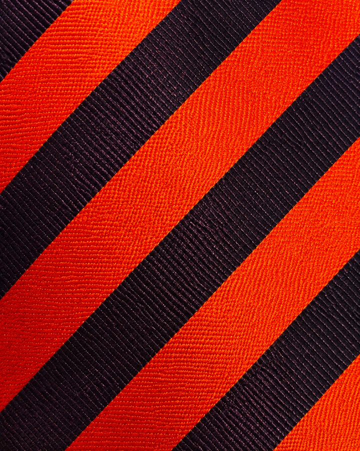 Närbild av randigt mönster på PUCK, bred slips i orange och lila