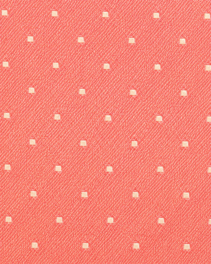 Närbild av små vita prickar och fyrkantiga motiv på rosa botten på ROSAMUNDA SMAL, smal slips i rosa och vitt