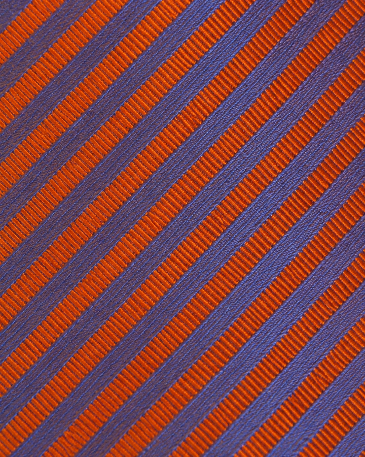 Närbild av diagonala ränder på RUDOLF, bred slips i blått och orange