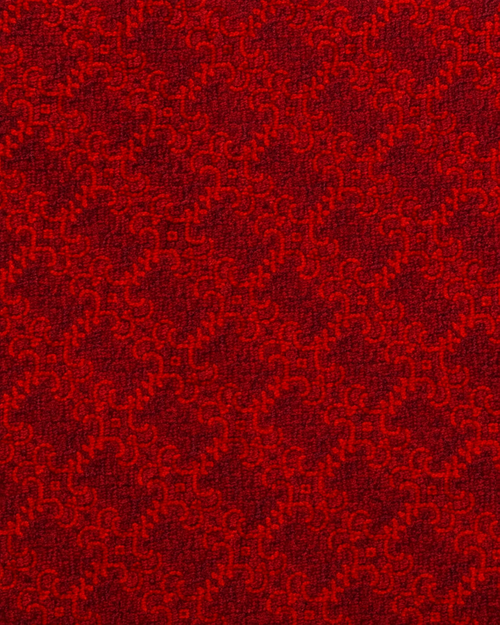 Närbild av ett tätt tonalt rött geometriskt upprepningsmönster på VERITAS, bröstnäsduk i rött i flera toner