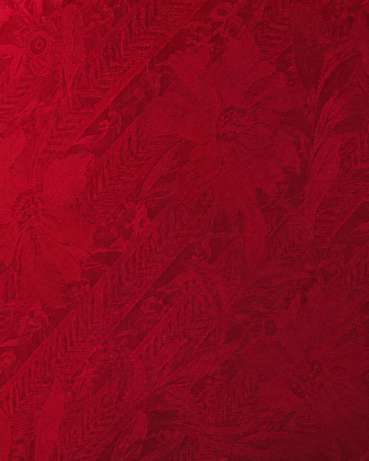 Närbild av tonala röda ornamentmotiv ordnade inom diagonala band på VICTORIA, slips i rött i flera toner