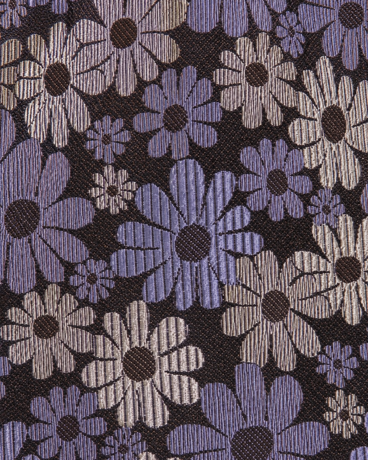 Närbild av blommigt motiv på VIOLET, bred slips i lila, vitt och svart