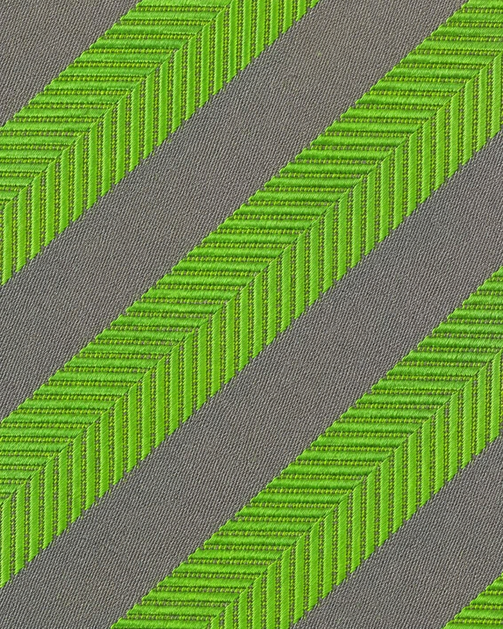 Närbild av mönstrade limegröna diagonala band växelvis med breda silverfärgade band på WASABI SMAL, smal slips i limegrönt och silver